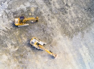 Aerial view of a excavator in open cast mine or on construction site. Heavy industry from above. Industrial background from drone.