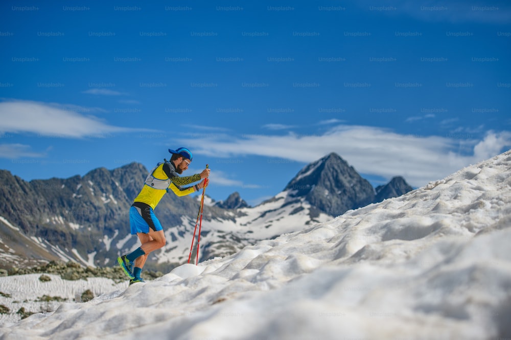 Entrenamiento de skyrunning con bastones en la nieve cuesta arriba