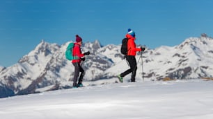 雪上を歩く2人の女性登山者