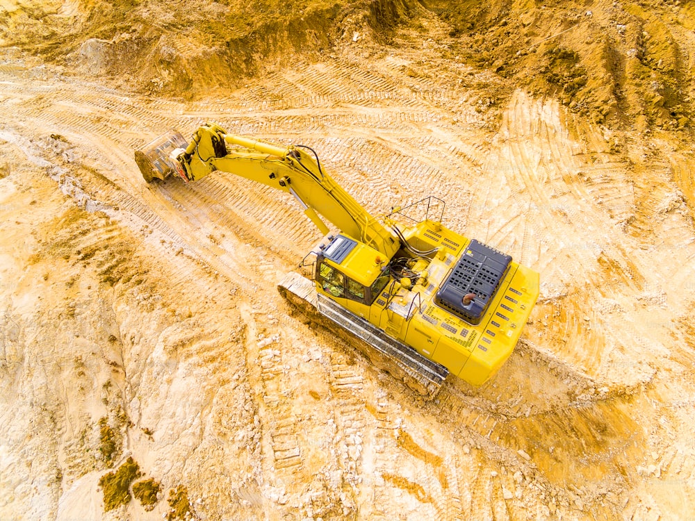 Aerial view of a excavator in open cast mine or on construction site. Heavy industry from above. Industrial photography from drone.
