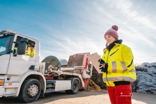 Managerin registriert LKW-Entladung von Biomasse in Kompostwerken