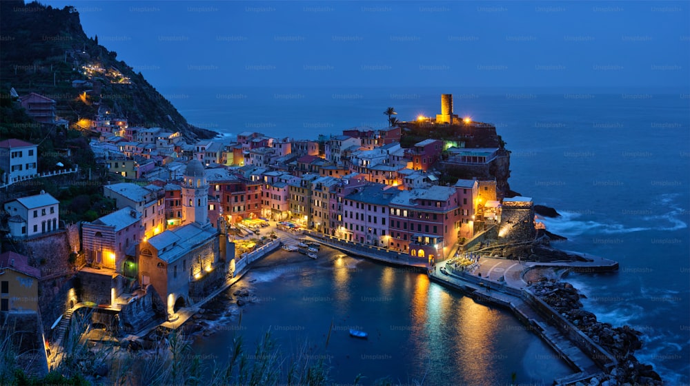 Veduta del villaggio di Vernazza popolare destinazione turistica nel Parco Nazionale delle Cinque Terre un patrimonio mondiale dell'UNESCO, Liguria, Italia vista illuminata nella notte dal sentiero azzurro