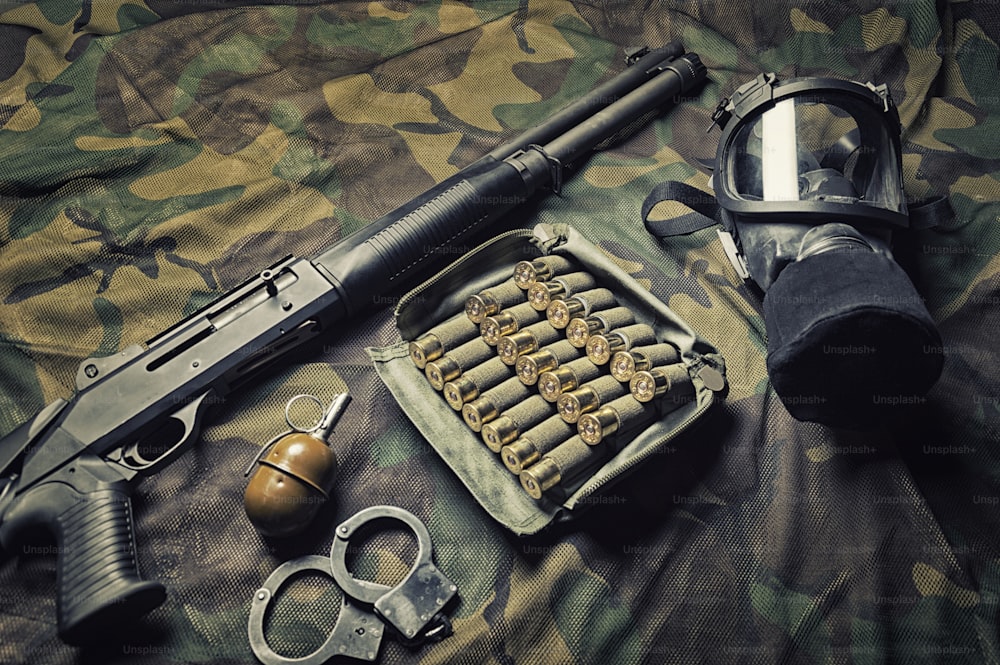 Conjunto de armas de un combatiente de una unidad especial. Escopeta, munición, granada, esposas y máscara antigás. Vista superior. Mixtas