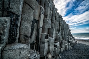 Wunderschöne und einzigartige vulkanische Felsformation am isländischen schwarzen Sandstrand in der Nähe des Dorfes Vik i Myrdalin Südisland. Sechseckige säulenförmige Felsen ziehen Touristen an, die Island besuchen.