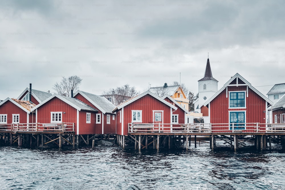 Casas de rorbu vermelho tradicionais na vila de pescadores de Reine no inverno. Ilhas Lofoten, Noruega