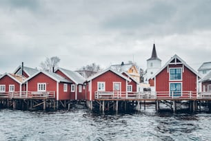 Traditional red rorbu houses in Reine fishing village in winter. Lofoten islands, Norway