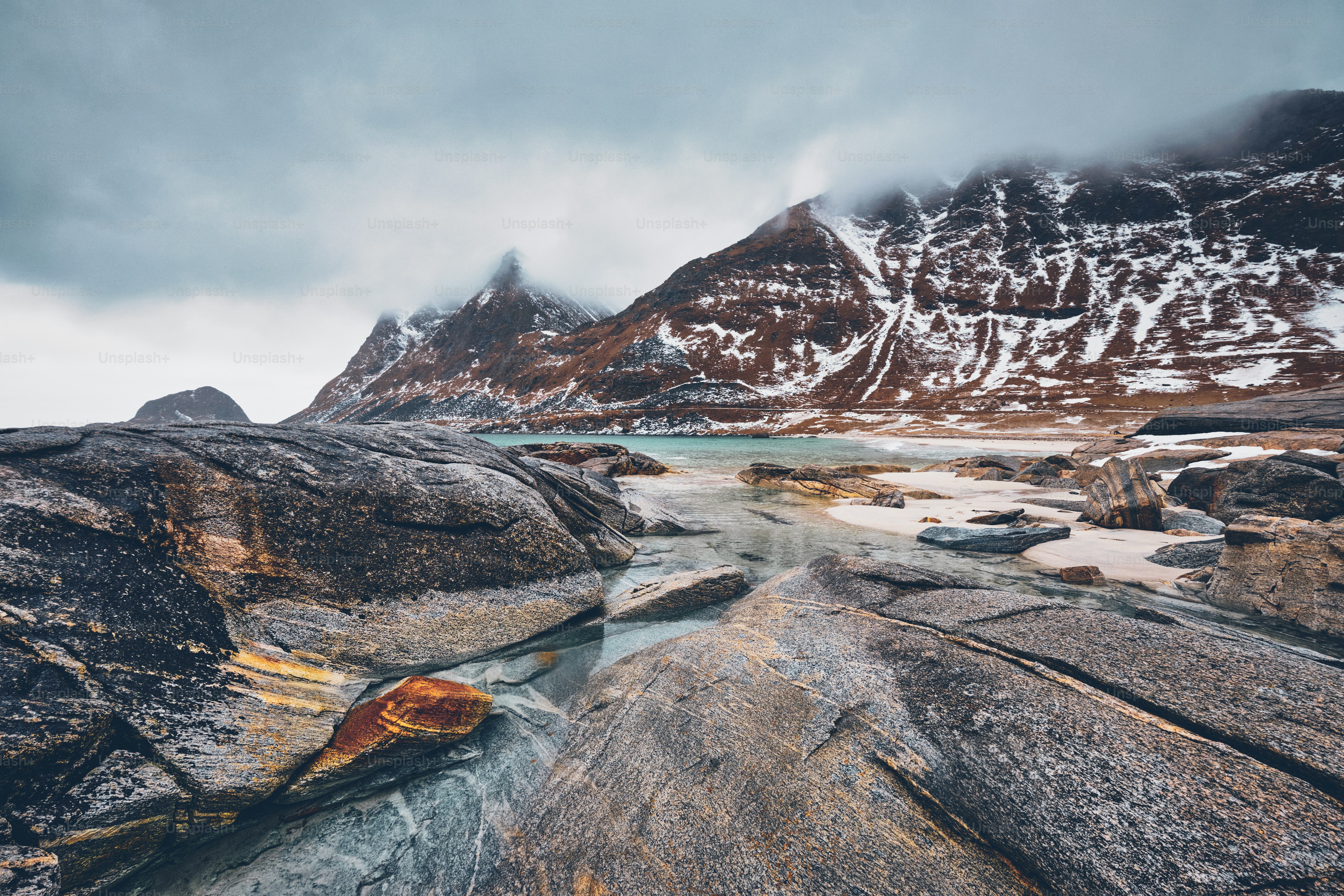 Rocky coast of fjord of Norwegian sea in winter with snow. Haukland beach, Lofoten islands, Norway