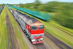 Güterzug fährt eilig mit hoher Geschwindigkeit durch den Zug. Schienenverkehrskonzept