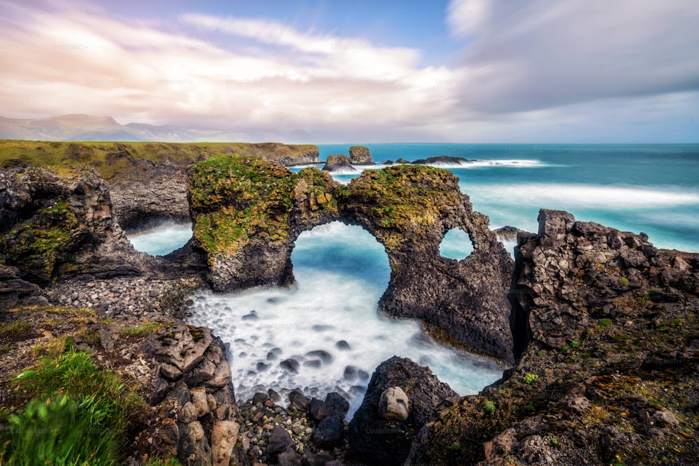 Incredibile arco di pietra Gatklettur roccia basaltica sulla costa atlantica di Arnarstapi in Islanda. Il famoso arco di forma naturale attrae i turisti da visitare nell'ovest dell'Islanda.