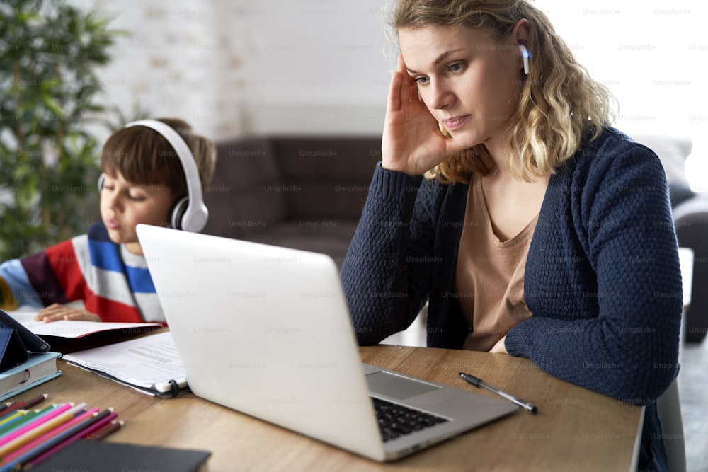 Frustrated mother during home office with her son at home