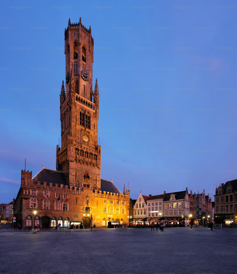 Torre del campanile famosa destinazione turistica e piazza Grote markt a Bruges, Belgio al crepuscolo al crepuscolo