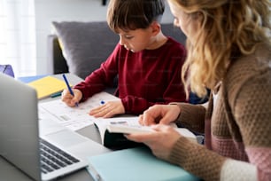 Madre ayudando a su hijo con las tareas escolares