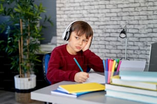 Boy is bored with homework at home