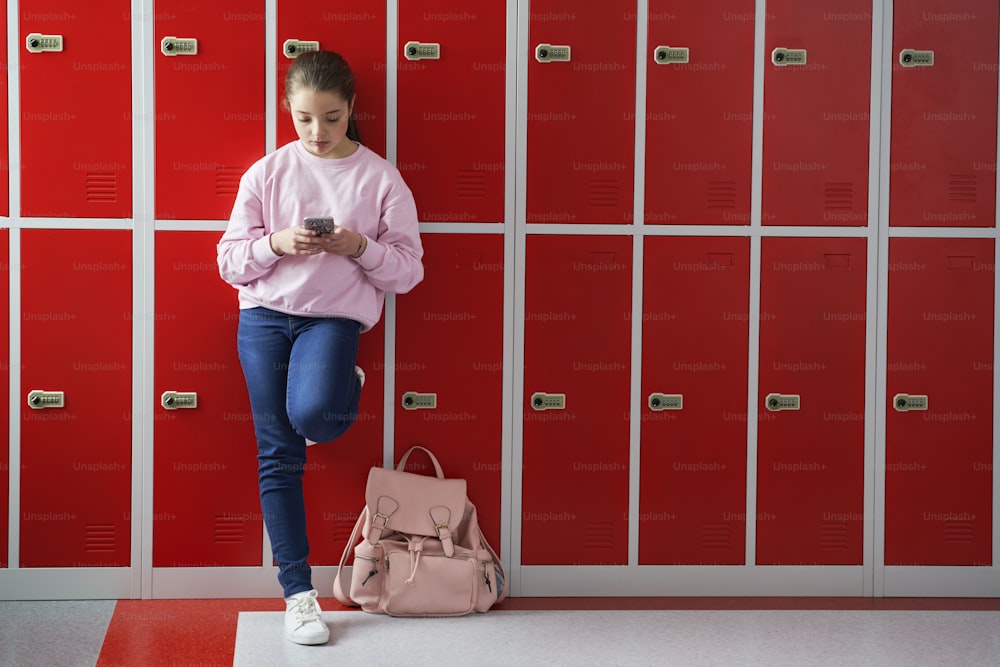 Schülerin mit Smartphone in der Schule