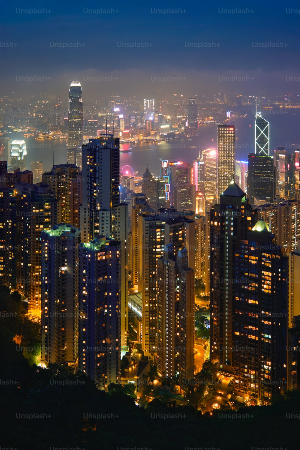 香港の有名な景色 - 香港の高層ビルのスカイライン、ビクトリアピークからの街並みの眺めは、夕方の青い時間に照らされています。香港、中国