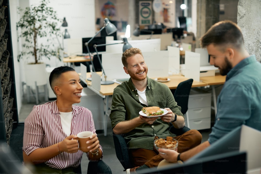 직장에서 점심 시간에 의사 소통하는 동안 즐거운 시간을 보내는 행복한 기업가의 다인종 그룹.