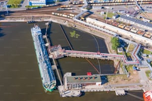 Aerial top view tanker at unloading in a large bulk port liquid cargo, oil, liquefied gas, fuel.