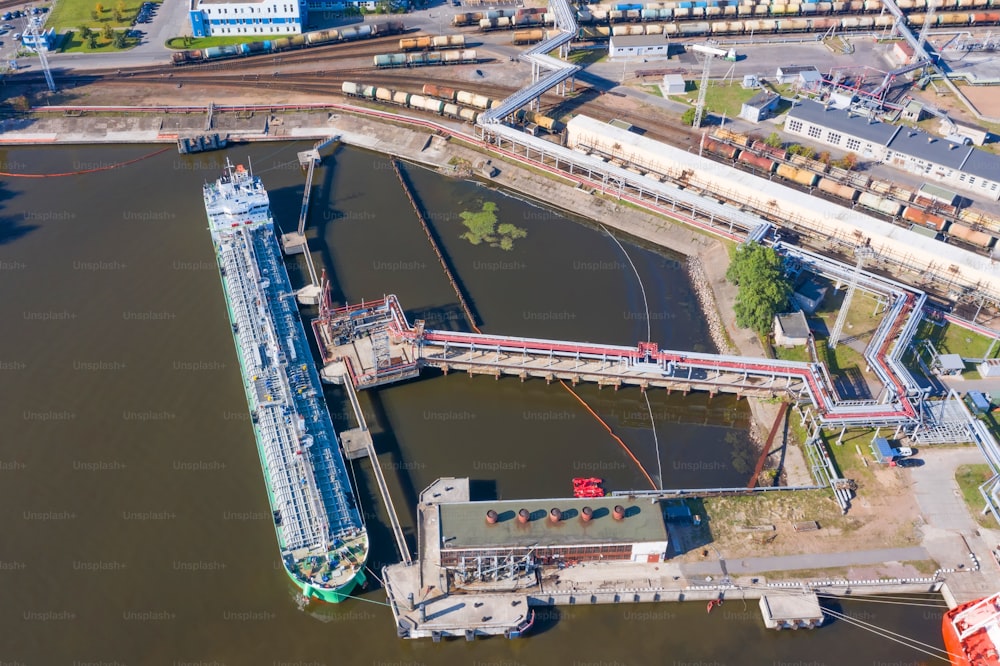 Aerial top view tanker at unloading in a large bulk port liquid cargo, oil, liquefied gas, fuel.