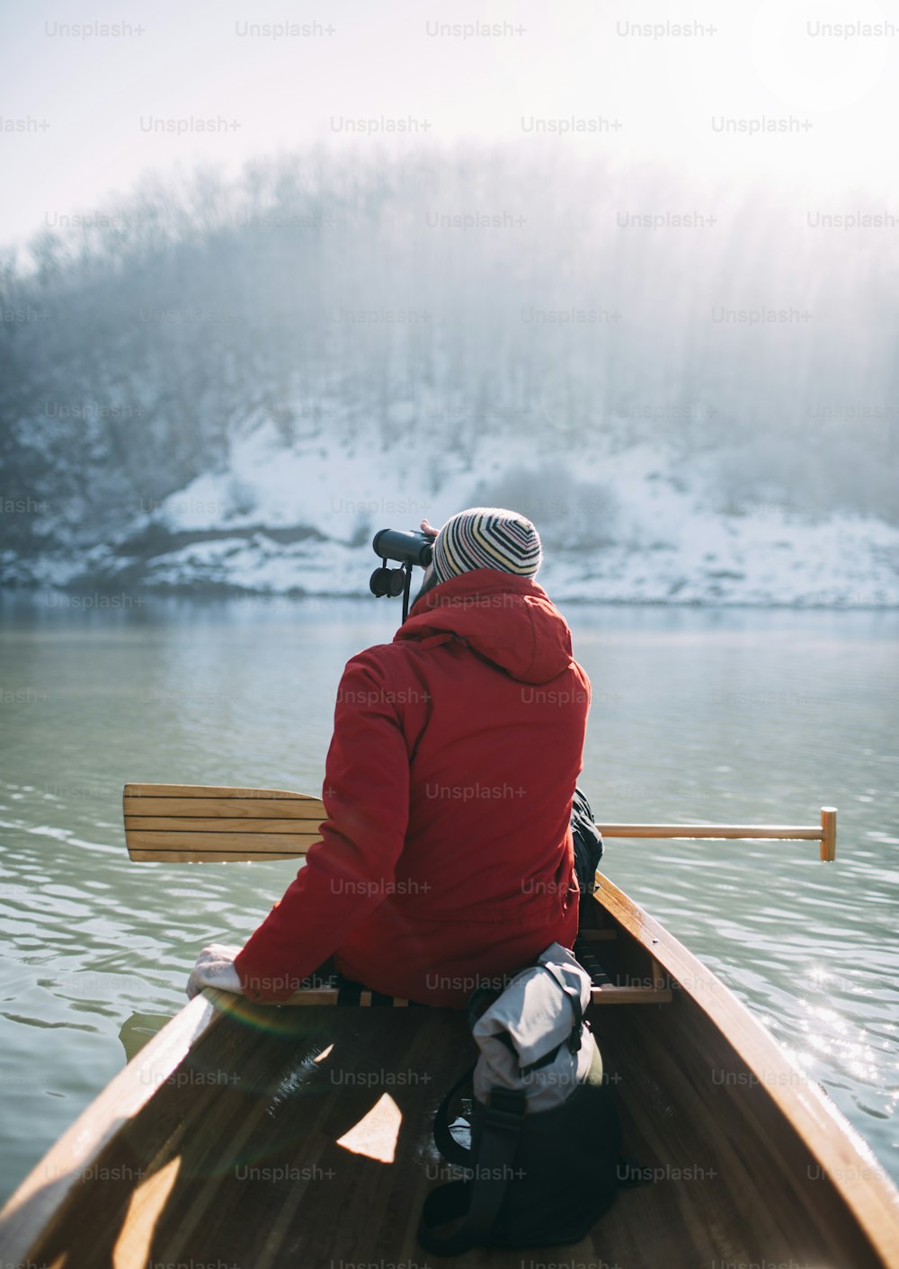 Rear view of man watching birds from the canoe.