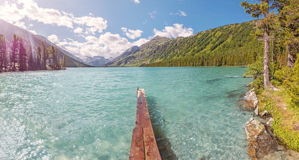 Muelle de madera para barcos de pesca en un pintoresco lago de montaña. Pesca en el parque nacional