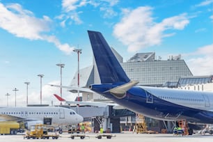 Aeronaves em manutenção pré-voo e suas caudas no aeroporto ao lado do terminal de passageiros