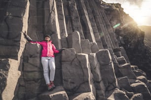 南アイスランドのヴィク・イ・ミルダリン村の近くにあるアイスランドの黒砂のビーチにあるユニークな火山岩層への旅行者の旅。六角形の柱状の岩は、アイスランドを訪れる観光客を魅了します。