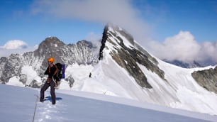 alpinista de pie sobre un glaciar y mirando el maravilloso paisaje montañoso y el panorama que lo rodea cerca del Jungfraujoch en los Alpes de Suiza