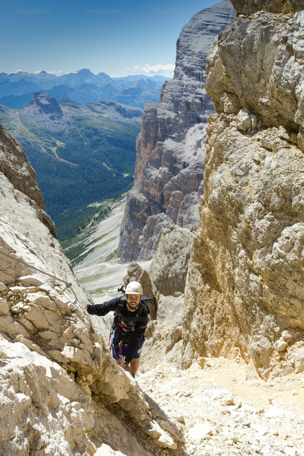 コルティナ・ダンペッツォ(Cortina d'Ampezzo)の上の急なフェラータ通り(Via Ferrata)の男性登山者
