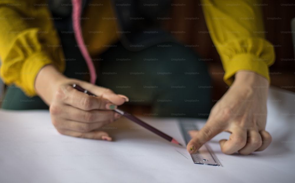 Worthy student hands. Young student girl writing on paper. Close up. Focus is on hands.