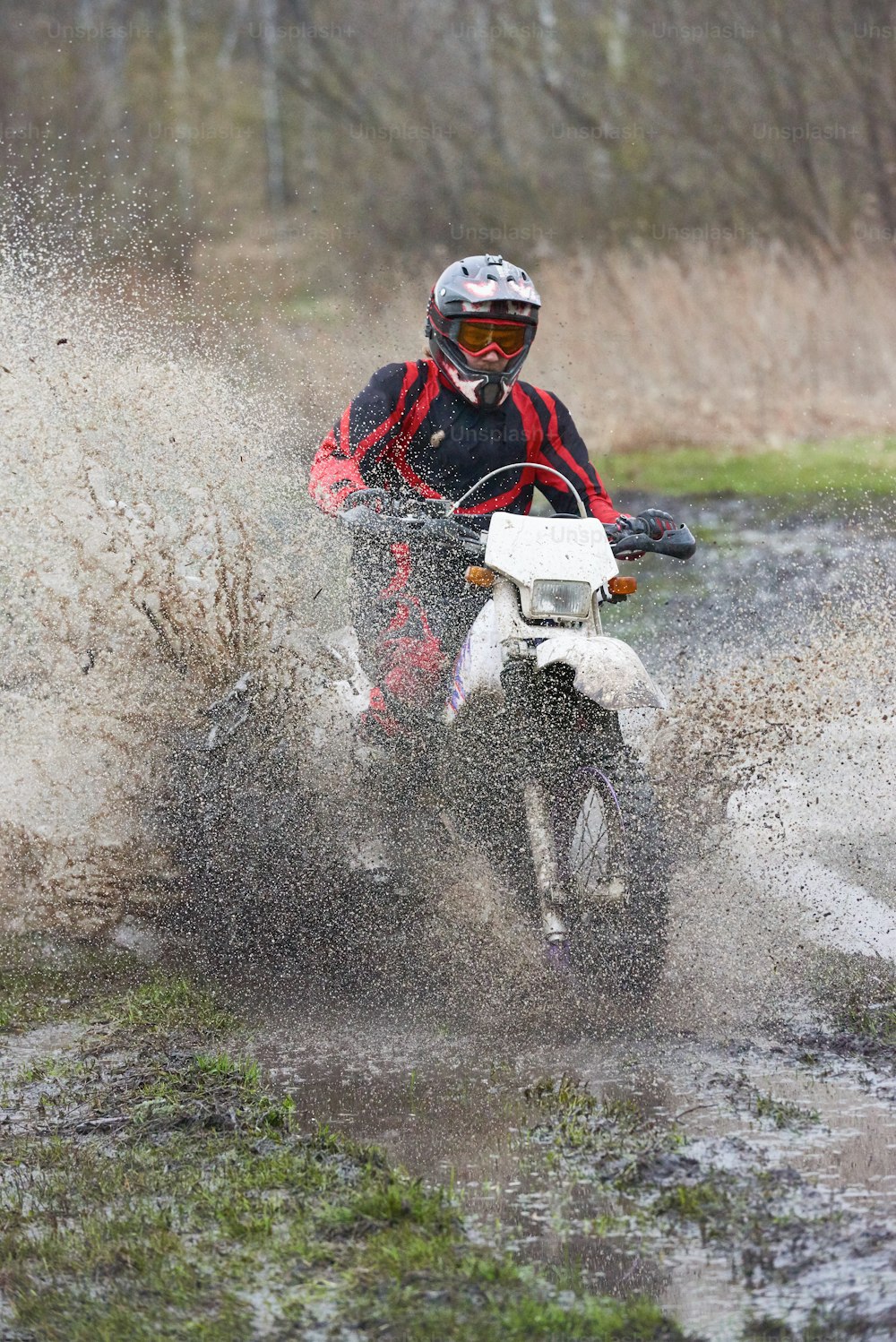Extreme racing on mud track where skilled man riding in puddle