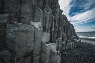 아이슬란드의 아름답고 독특한 화산암 형성 검은 모래 해변은 Vik i myrdalin South Iceland 마을 근처에 있습니다. 육각형 원주 형 바위는 아이슬란드를 방문하는 관광객을 끌어들입니다.