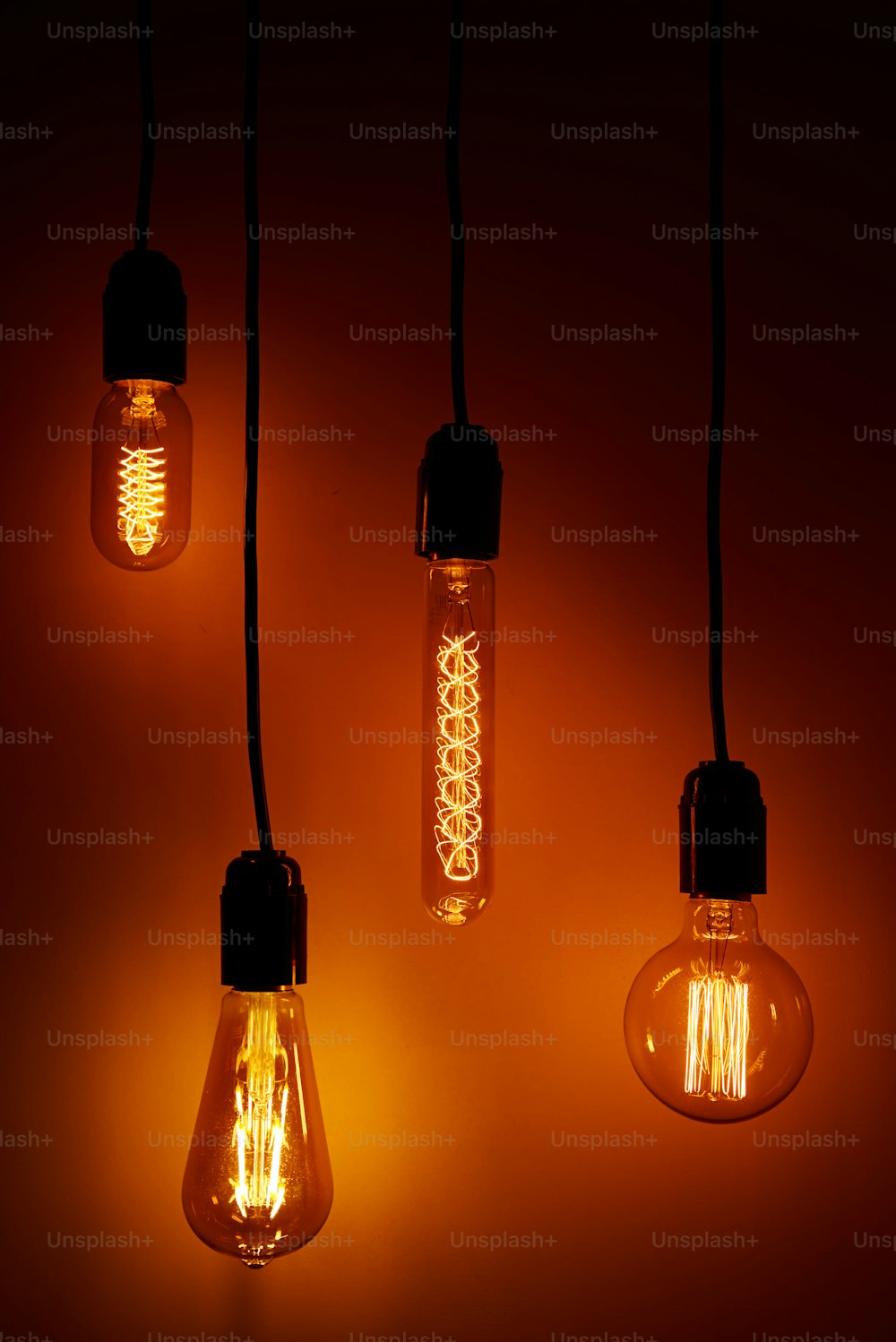 オレンジ色の背景にビンテージ電球のセット。光るエジソン電球