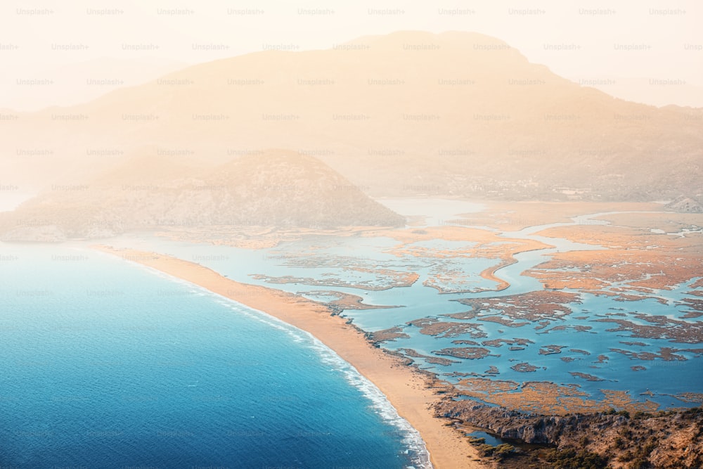 Scenic aerial paniramic view from mountain Bozburun to Iztuzu beach and the Dalyan river Delta as well as lake Sulungur at sunset time. Majestic autumn landscape. Explore natural wonders of Turkey