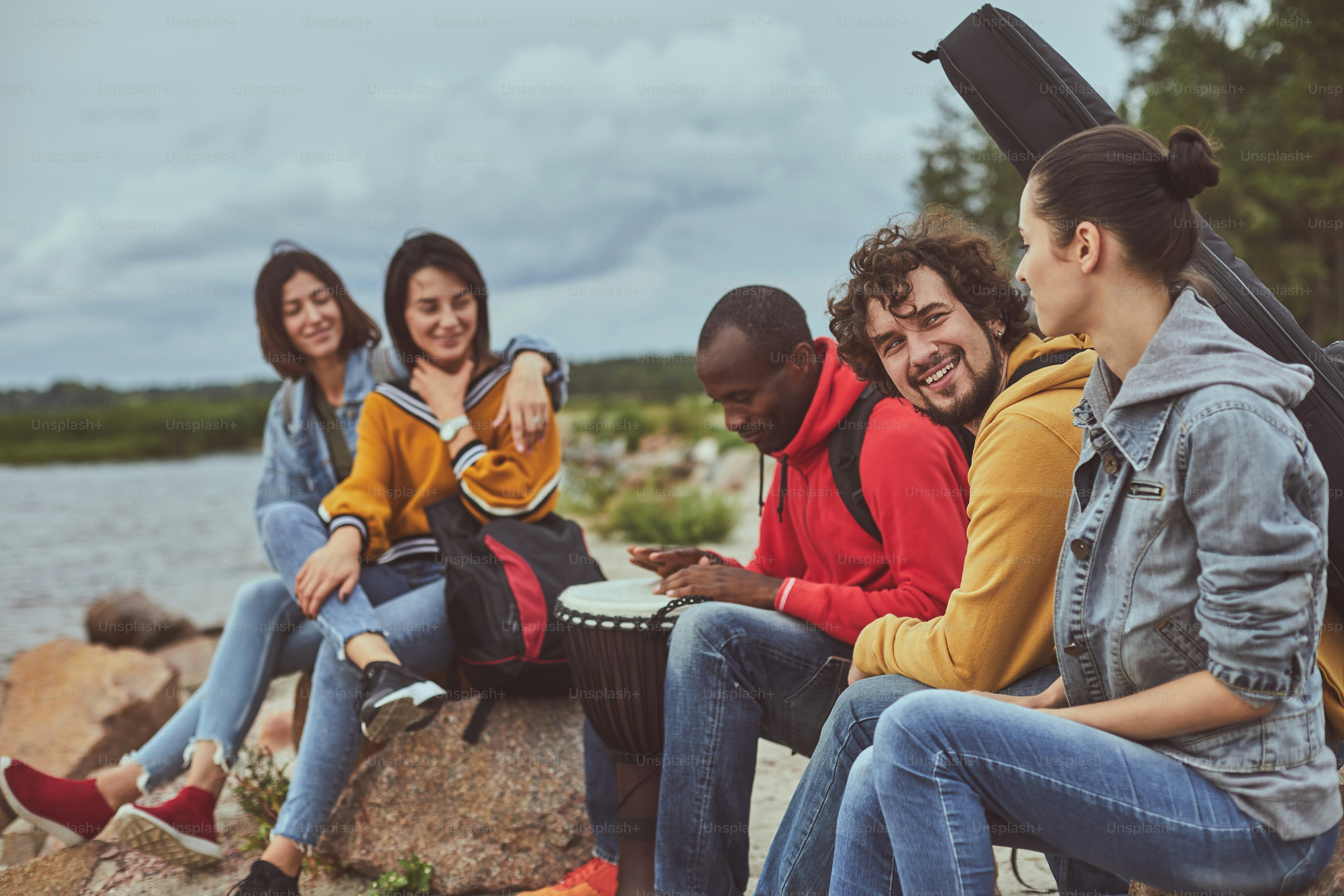 Having good time. Portrait of group of smile travelers enjoying drum melody while playing by musician