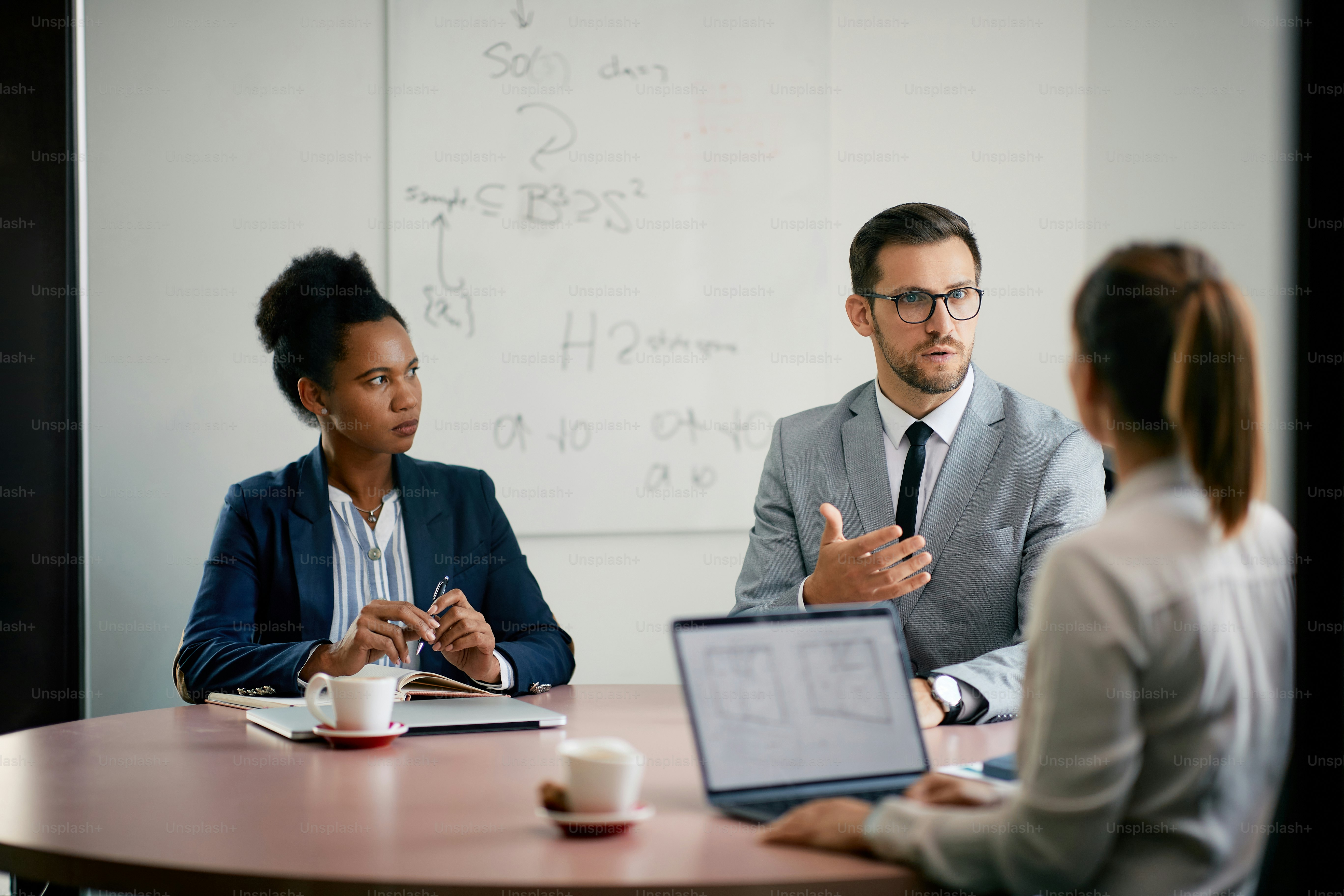 Serious businessman and his female colleagues communicating on a meeting int he office.