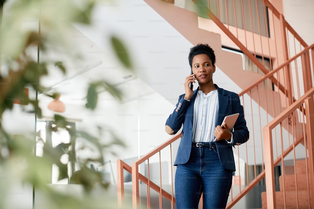 African American businesswoman making phone call in a lobby of an office building.