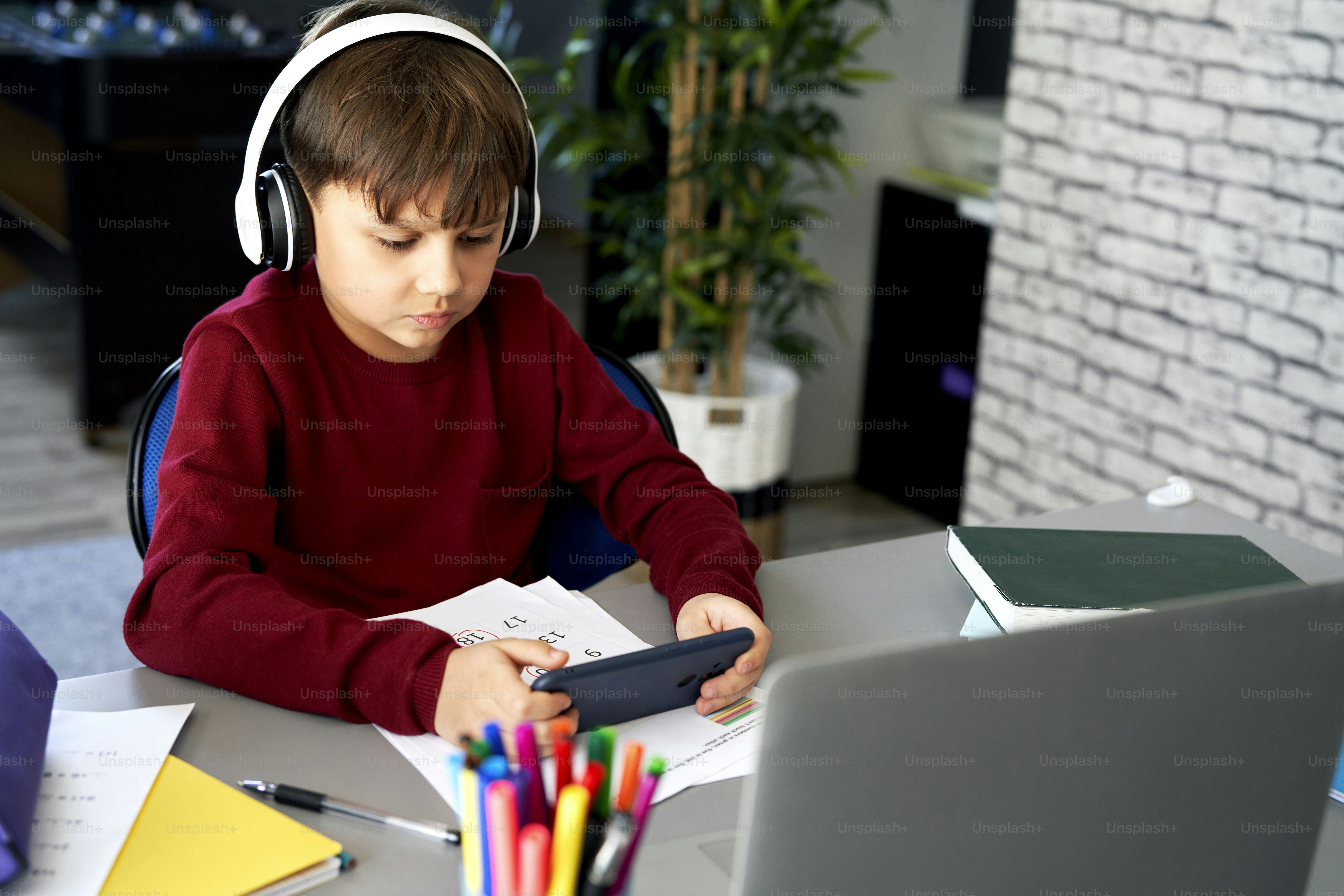 Schoolboy playing on the phone during homeschooling