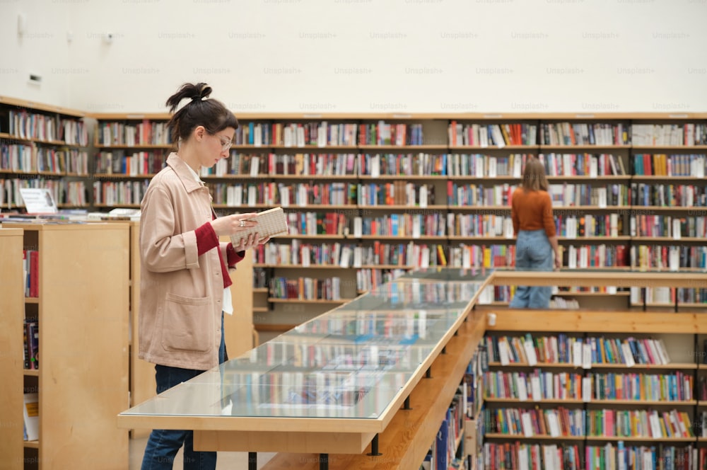 Young people studying in the library and choosing books for reading