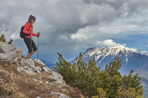 Chica de descenso durante un trekking alpino en los Alpes