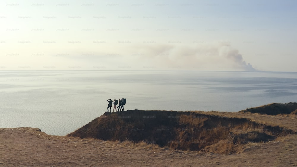 Die vier Touristen spazieren an der felsigen Küste