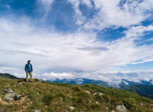 El hombre de pie sobre la roca contra hermosas nubes