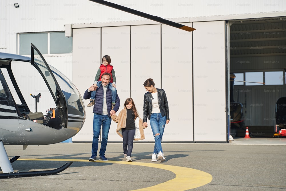 Dad and mom smiling and taking their cute kids on an airplane adventure