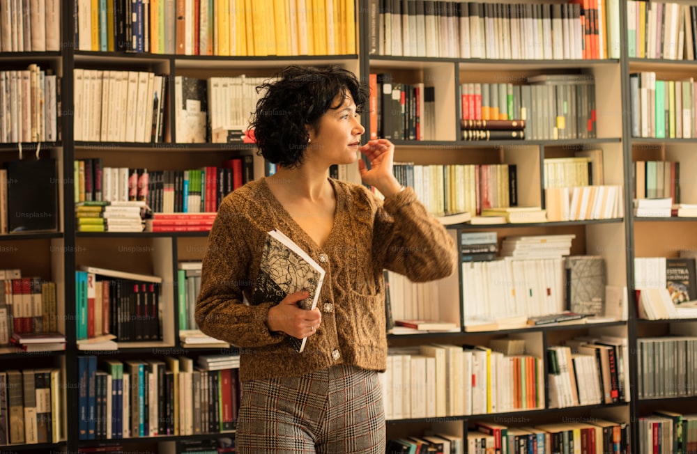 Woman with book in library.