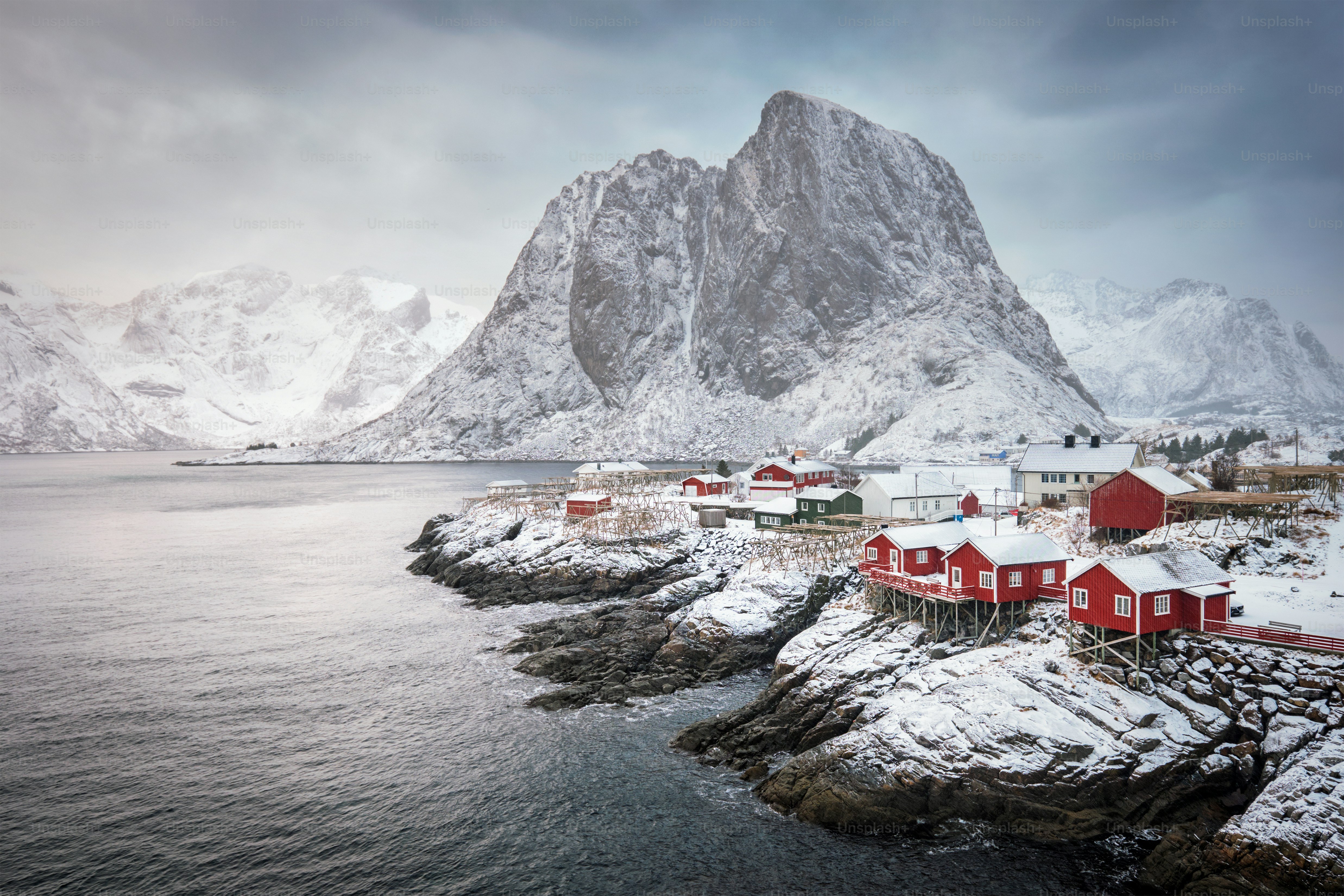Famosa attrazione turistica Hamnoy villaggio di pescatori sulle isole Lofoten, Norvegia con case rorbu rosse. Con la neve che cade in inverno all'alba