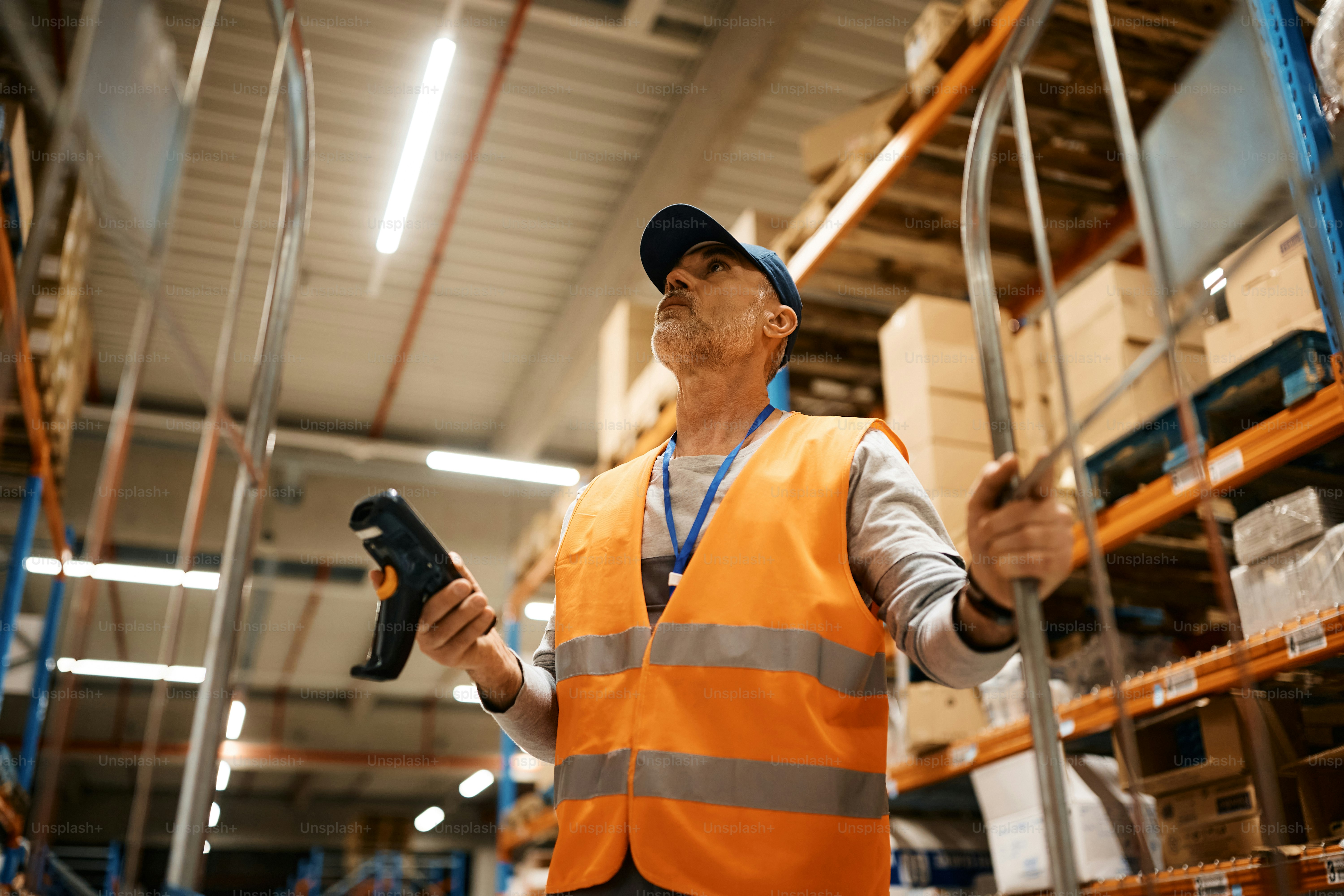 Warehouse worker scanning barcodes on shelves in a busy distribution centre