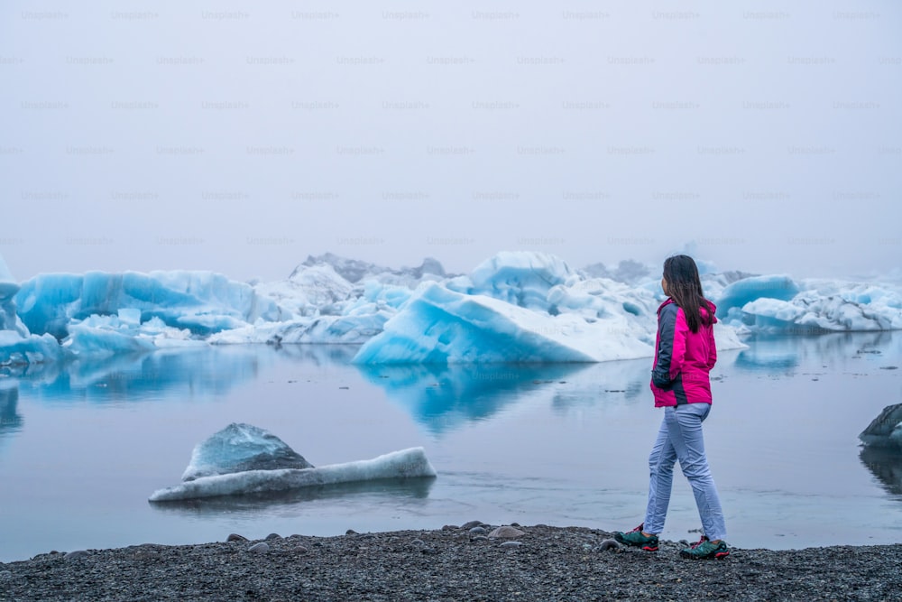 Una viajera viaja a la hermosa laguna glaciar de Jokulsarlon en Islandia. Jokulsarlon es un famoso destino en el Parque Nacional de Vatnajökull, en el sureste de Islandia, Europa. Naturaleza fría de hielo invernal.