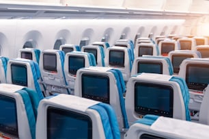 Asientos de pasajeros con pantalla para controlar y ver archivos multimedia durante el vuelo en avión