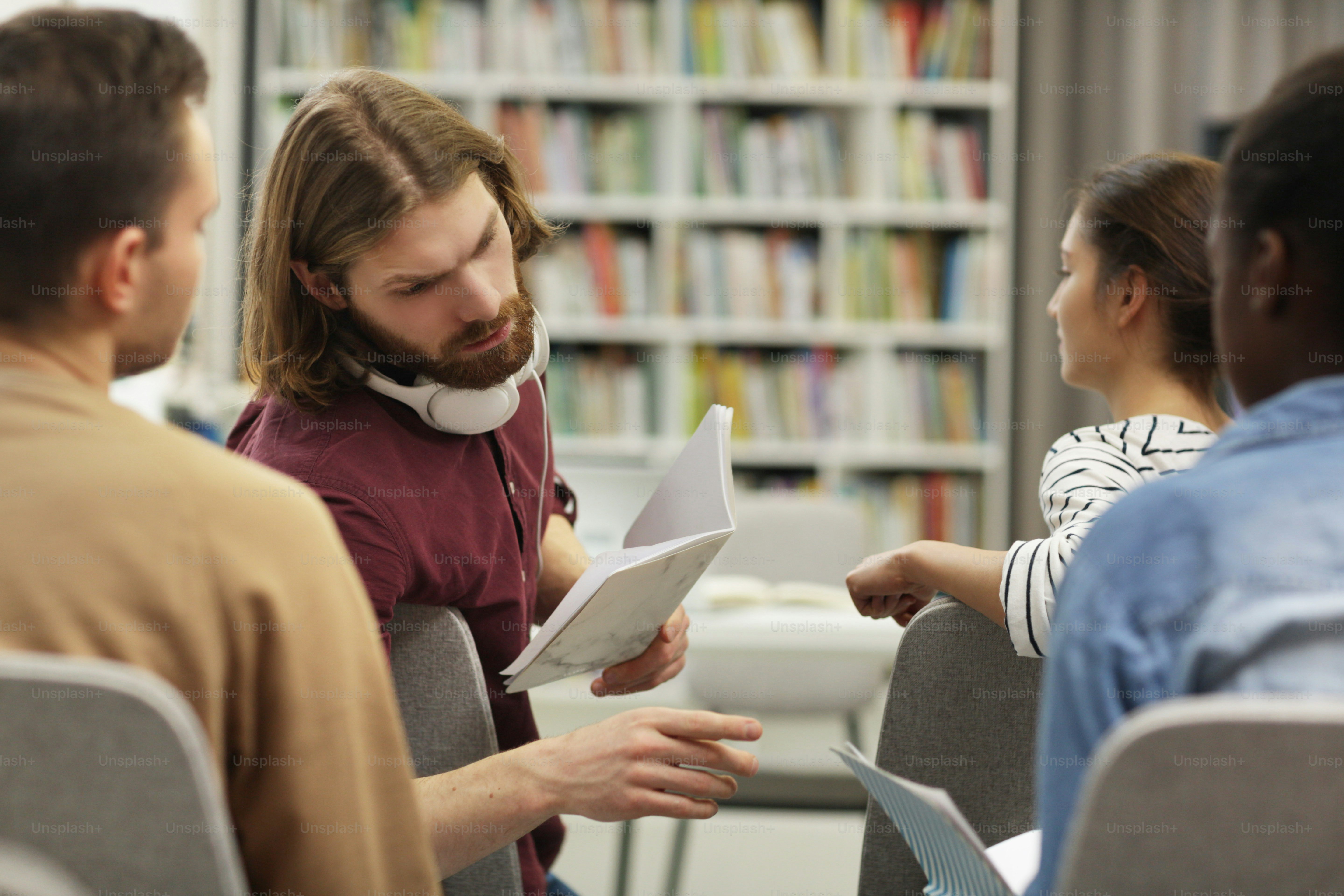 Des jeunes discutent de quelque chose et travaillent en équipe tout en étant assis à un séminaire d’entreprise