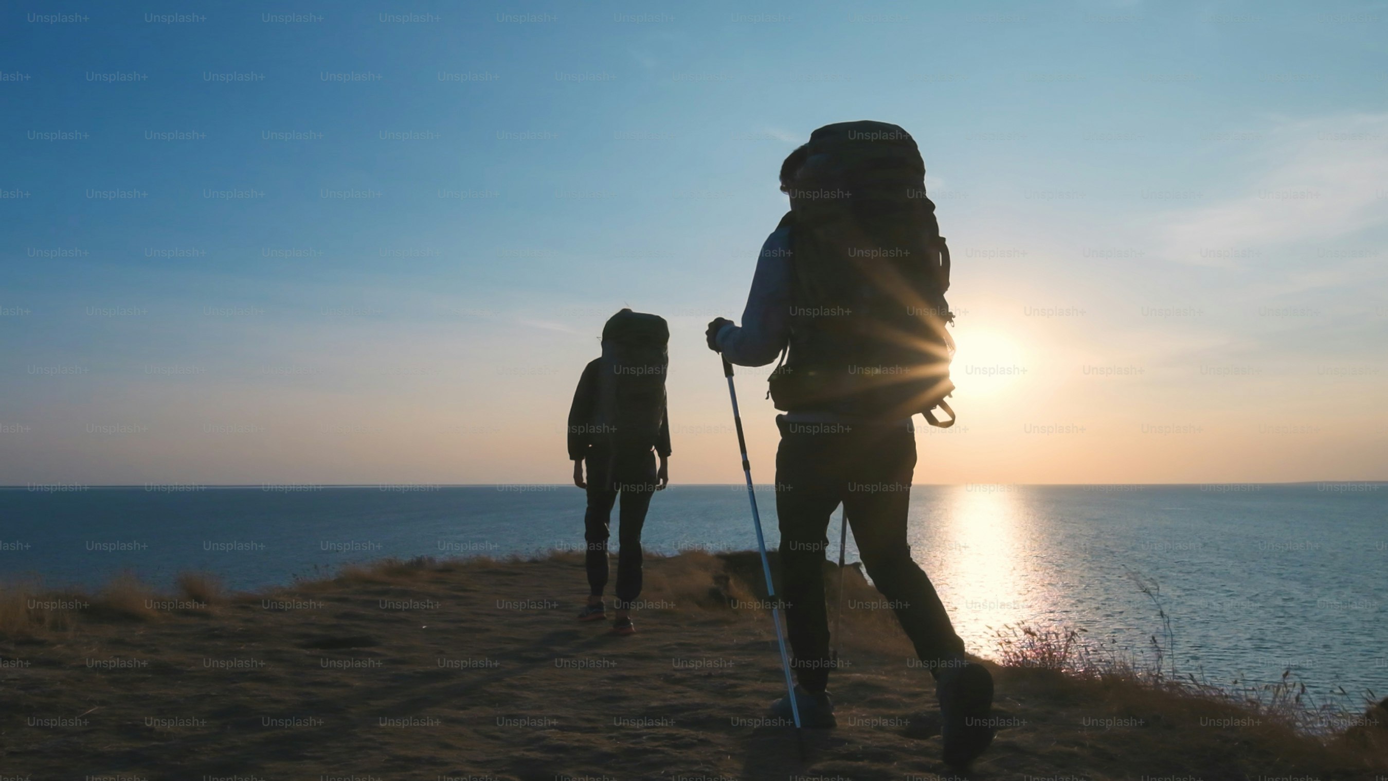 Die Reisenden, die auf dem Hintergrund der Meereslandschaft spazieren