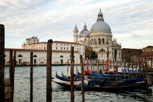 Gondola boats in Venice Italy with gorgeous view of Basilica Santa Maria della Salute. Venice is famous travel destination in Italy for its unique cityscape and culture.